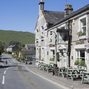 a street with tables and chairs outside of a building at Bulls Head, Castleton in Castleton