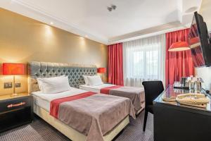 a hotel room with two beds and a desk at Khreschatyk Hotel in Kyiv