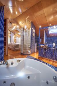 een grote badkamer met een bad en een slaapkamer bij Duplex Monforte in Monforte de Lemos