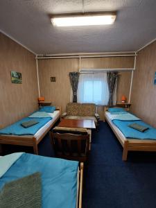 a room with three beds and a table at Hostel SuzZzy in Novska