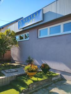 a building with two flower pots in front of it at Hostel Suzzzy in Novska +16 photos