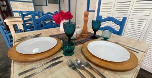 einem Holztisch mit zwei weißen Tellern und Besteck in der Unterkunft Posada Lagunita in Los Roques