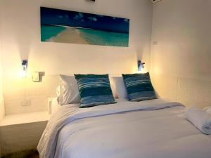 ein Schlafzimmer mit einem weißen Bett mit zwei Kissen in der Unterkunft Posada Lagunita in Los Roques