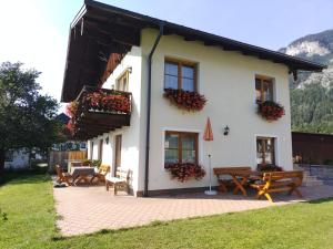 a white house with benches and flowers in front of it at Berningerhof in St. Wolfgang +14 photos