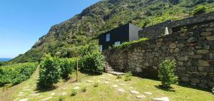 a house on a mountain with a stone wall at Terrabona Nature & Vineyards in Boaventura