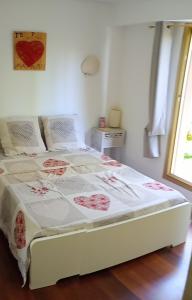 ein weißes Bett mit einer Decke in einem Schlafzimmer in der Unterkunft Résidence de Croisset in Grasse
