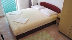 a bed with two towels on it in a room at Apartments Primorac Podaca in Podaca