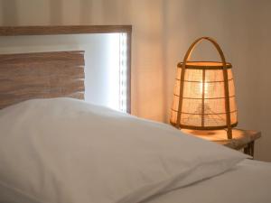 L'épicurien • Cœur de ville • Confortable في شاتورو: غرفة نوم بسرير ابيض ومصباح