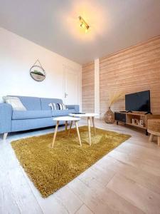 L'épicurien • Cœur de ville • Confortable في شاتورو: غرفة معيشة مع أريكة زرقاء وطاولة
