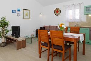 una cucina e un soggiorno con tavolo e sedie di Robinzon Villa Zavala a Povlja