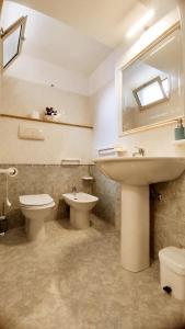 a bathroom with a sink and a toilet and a mirror at Casa alla Costa in Mormanno +17 photos