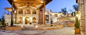 a large stone building with a courtyard with lights at Kazarma Hotel in Kalyvia Fylaktis