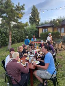 een groep mensen die rond een tafel eten bij Hostel I Keu Ken in El Calafate
