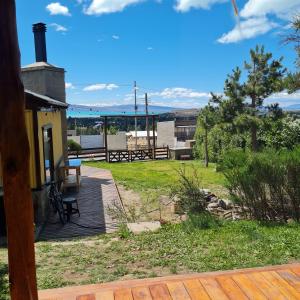 a deck with a picnic table and benches on it at Hostel I Keu Ken in El Calafate