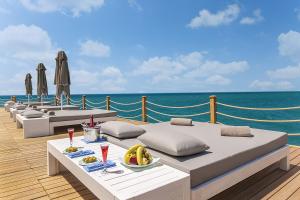 una terraza con camas y una mesa con un bol de fruta en Sirene Belek Hotel, en Belek