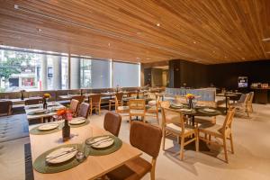 a restaurant with wooden ceilings and tables and chairs at Radisson Pinheiros in São Paulo