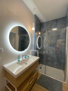 a bathroom with a sink and a shower with a mirror at Bel Mare Aqua Resort 508 in Międzyzdroje