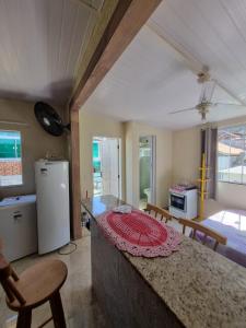 a kitchen with a counter with chairs and a table at Kitnets da Tia Zeni in Arraial do Cabo