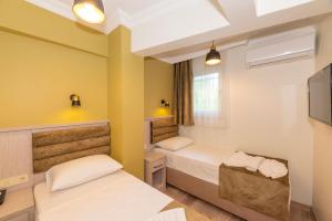Cette chambre comprend 2 lits et une télévision. dans l'établissement Bazaar Hotels Old City, à Istanbul