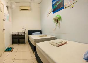 a room with two beds in a room at Prima B&B Hostel in Sandakan