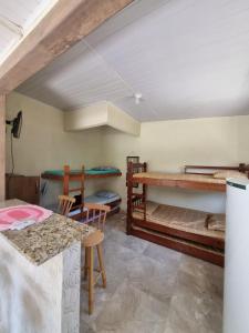 a room with two bunk beds and a table at Kitnets da Tia Zeni in Arraial do Cabo