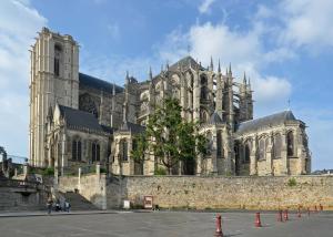 eine große Kathedrale mit einer Steinmauer davor in der Unterkunft Artyster Le Mans in Le Mans