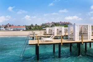 a dock with chairs on the water next to a beach at Sirene Belek Hotel in Belek