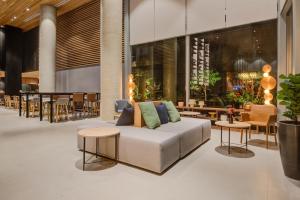uma sala de estar com um sofá branco e mesas em Radisson Pinheiros em São Paulo