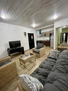 a living room with a couch and chairs and a piano at South La Apartments in Accra