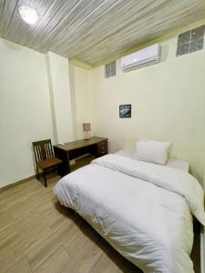 a bedroom with a bed and a desk with a chair at South La Apartments in Accra