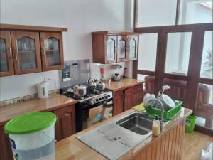 cocina con fregadero y fogones horno superior en Alojamiento Casa Grande en Iquitos