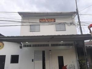 a white building with a sign on the top of it at Alojamiento Casa Grande in Iquitos