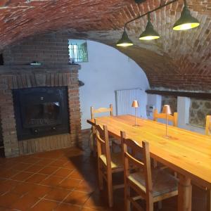 a dining room with a long table and a fireplace at CascinaMirta in Andorno Micca