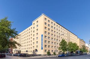 ein großes weißes Gebäude mit blauem Schild drauf in der Unterkunft a&o Berlin Mitte in Berlin