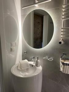 a white bathroom with a sink and a mirror at Lux apartment near Wawel in Krakow