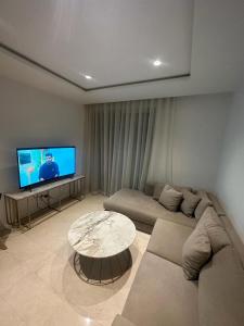 a living room with a couch and a table at Luxury Appt casa finance City CFC-Aeria Mall in Casablanca