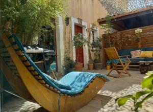 een patio met een bank en een stoel in de tuin bij studio cosy à 10 minutes de Nîmes in Bouillargues