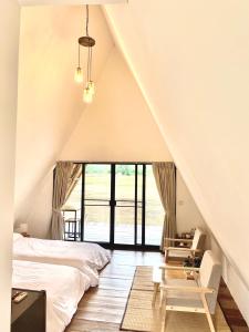a attic bedroom with a bed and a window at Khao Kiang Na เขา เคียง นา in Ban Muang Kut