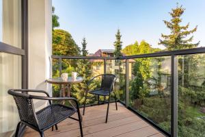 a patio with two chairs and a table on a balcony at Apartament Flora - apartament blisko morza in Gdańsk