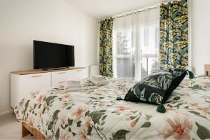 a bedroom with a bed with a tv on it at Apartament Flora - apartament blisko morza in Gdańsk