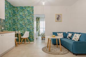 a living room with a blue couch and a table at Apartament Flora - apartament blisko morza in Gdańsk +18 photos
