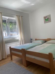 een slaapkamer met 2 bedden en een raam bij Guesthouse Abrlic in Seliste Dreznicko
