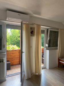 een woonkamer met glazen schuifdeuren en een patio bij Guesthouse Abrlic in Seliste Dreznicko