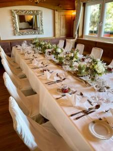 a long table with white table cloths and flowers at Panoramahotel Steirerland in Kitzeck im Sausal