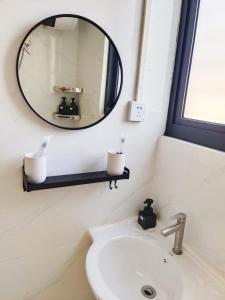 a bathroom with a mirror and a sink at 闲肆民宿 in Sanya