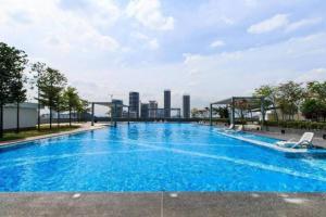a large blue swimming pool with a city skyline in the background at Urban-Nature Retreat Encorp Strand Alpha IVF 3px in Petaling Jaya