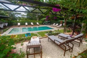 a swimming pool with chairs and a table next to it at Rinconcito Lodge in Liberia +48 photos