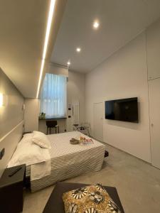 Civico29 appartamento bilocale في كومو: غرفة نوم بسرير وتلفزيون بشاشة مسطحة