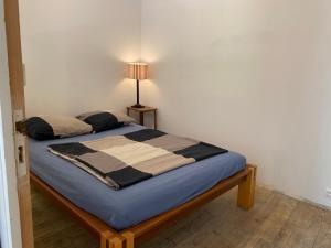 ein Schlafzimmer mit einem Bett mit einer Lampe in der Unterkunft Maison à fleurs in Granville