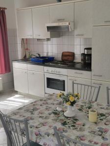 a kitchen with a table with a vase of flowers on it at Pension zum Park in Goldberg